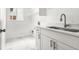Well-lit laundry room with modern cabinets and white marble-styled tile flooring at 11383 Oakland Dr, Commerce City, CO 80640