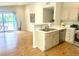 Bright kitchen featuring wood floors, ample counter space, stainless steel dishwasher, and view to living space and deck at 3727 Cactus Creek Ct # 204, Highlands Ranch, CO 80126