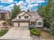 Aerial view of the property features a two-story home, large lot, mature landscaping, and a three-car garage at 5814 Cole Way, Arvada, CO 80004