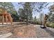 Picturesque backyard boasting garden space, a fire pit, mature trees, and a deck with staircase at 5814 Cole Way, Arvada, CO 80004