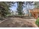 Spacious backyard featuring a fresh garden, mature trees, and a wooden deck with staircase at 5814 Cole Way, Arvada, CO 80004