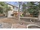 Large backyard with a wooden deck, a stone fire pit, garden, and mature trees at 5814 Cole Way, Arvada, CO 80004