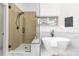 Modern bathroom featuring a glass shower, standalone tub, marble accents, and black fixtures at 5814 Cole Way, Arvada, CO 80004
