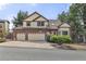 Well-maintained two-story home featuring a manicured lawn, brick accents, bay window, and three-car garage at 5814 Cole Way, Arvada, CO 80004