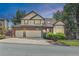 Charming two-story home featuring a well-maintained lawn, brick accents, bay window, and a spacious three-car garage at 5814 Cole Way, Arvada, CO 80004