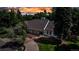 Beautiful home surrounded by lush trees, showcasing its elegant exterior and landscaped yard at sunset at 17 E Belleview Ln, Greenwood Village, CO 80121