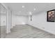 Large finished basement with new laminate flooring, mirrored wall, and egress windows at 17 E Belleview Ln, Greenwood Village, CO 80121