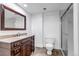 Basement bathroom features granite counters, wood cabinets, and a tiled shower at 17 E Belleview Ln, Greenwood Village, CO 80121