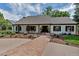 Charming single-story home with a brick pathway, lush landscaping, and black-trimmed windows at 17 E Belleview Ln, Greenwood Village, CO 80121