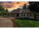 Lovely single-story home with brick pathway, lush landscaping, and black-trimmed windows at sunset at 17 E Belleview Ln, Greenwood Village, CO 80121
