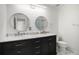 Bright bathroom featuring double sinks with granite countertops, decorative mirrors, and toilet at 20604 E 38Th Pl, Denver, CO 80249