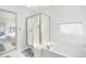 Bright bathroom featuring a glass-enclosed shower, soaking tub, and tile flooring at 20604 E 38Th Pl, Denver, CO 80249