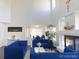 Bright living room boasts soaring ceilings, a fireplace and comfortable blue furniture at 20604 E 38Th Pl, Denver, CO 80249