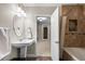 Cozy bathroom with pedestal sink, an oval mirror and a tiled shower and tub at 4788 Silver Pine Dr, Castle Rock, CO 80108
