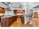 Spacious kitchen with wood cabinets, stainless steel appliances, and an island with a cooktop at 4788 Silver Pine Dr, Castle Rock, CO 80108