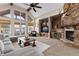 Inviting living room features a stone fireplace, built-in shelving, vaulted ceiling, and great natural light at 4788 Silver Pine Dr, Castle Rock, CO 80108