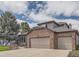 Beautiful two-story home featuring a brick facade and three-car garage at 6340 Ashburn Ln, Highlands Ranch, CO 80130