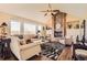 Bright living room boasts large windows, vaulted ceilings, and a cozy brick fireplace at 6340 Ashburn Ln, Highlands Ranch, CO 80130