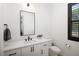 Stylish half-bath features modern fixtures, a white vanity, and black-framed mirror at 3149 W 35Th Ave, Denver, CO 80211