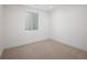 Clean bedroom featuring a window with barred security access and cream walls and carpet at 3149 W 35Th Ave, Denver, CO 80211