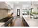 Well-lit kitchen with stainless steel range and hood, island and neutral-toned backsplash at 3149 W 35Th Ave, Denver, CO 80211