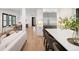 Bright, open-concept layout connecting kitchen with stainless steel appliances and breakfast bar to the dining area at 3149 W 35Th Ave, Denver, CO 80211