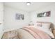 Comfortable bedroom featuring wood-look floors, white walls and pink and tan bedding accents at 8307 E Lehigh Dr, Denver, CO 80237