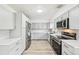 Updated kitchen features white counters, grey cabinets and stainless steel appliances at 8307 E Lehigh Dr, Denver, CO 80237
