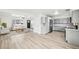 Bright, open-concept living room featuring a modern kitchen and hardwood floors at 8307 E Lehigh Dr, Denver, CO 80237