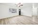 Spacious living area featuring natural light, wood-look flooring, ceiling fan and a view of the front door at 8307 E Lehigh Dr, Denver, CO 80237