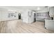 Open concept living space with grey cabinets, stainless appliances and light-colored floors at 8307 E Lehigh Dr, Denver, CO 80237