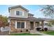 Charming two-story home featuring a stone facade, covered porch, and well-maintained lawn at 11738 Zenobia Loop, Westminster, CO 80031