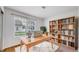 Bright office space with large window, light wood desk, stylish chair, and a bookshelf at 11738 Zenobia Loop, Westminster, CO 80031