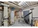 Unfinished basement area includes water heater, plumbing and electrical systems at 3670 Ivanhoe St, Denver, CO 80207
