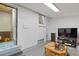 Finished basement with white-painted brick, window, and a cozy seating area at 3670 Ivanhoe St, Denver, CO 80207