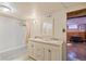 A bright bathroom featuring a dual sink vanity, tub with shower and nice mirror at 3670 Ivanhoe St, Denver, CO 80207