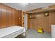 An unfinished room with paneled walls, storage area, and lighting at 3670 Ivanhoe St, Denver, CO 80207