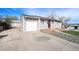 View of gray house with an attached one car garage, updated windows and a front yard with rock and turf at 8441 Mcdougal St, Denver, CO 80229