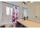 Bright bathroom features a shower-tub combo, framed mirror and floral shower curtain at 7729 Beverly Blvd, Castle Pines, CO 80108