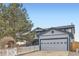 A charming home with a two-car garage and a white picket fence, framed by lush green foliage at 7729 Beverly Blvd, Castle Pines, CO 80108