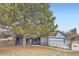 Cozy two-story home with a covered porch, two-car garage, mature trees, and a white picket fence at 7729 Beverly Blvd, Castle Pines, CO 80108
