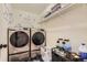 Efficient laundry room with front load washer/dryer, storage, and shelving at 7729 Beverly Blvd, Castle Pines, CO 80108