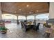 Covered outdoor patio space with stone columns, ceiling fans, and outdoor dining furniture at 16301 Hudson Rd, Hudson, CO 80642