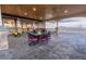 An outdoor covered patio area featuring a dining table with views of the land beyond at 16301 Hudson Rd, Hudson, CO 80642