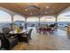 Covered outdoor patio with stone columns, ceiling fans, and an outdoor dining table with views of the land at 16301 Hudson Rd, Hudson, CO 80642