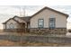 Attractive home with stone accents, neutral siding, and a well-maintained lawn at 16301 Hudson Rd, Hudson, CO 80642