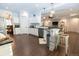 Open concept kitchen with white cabinets, dark countertops, and stone breakfast bar with pendant lighting at 16301 Hudson Rd, Hudson, CO 80642