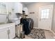Well-organized laundry room with washer, dryer, sink, and storage cabinets, accented by a floral rug at 16301 Hudson Rd, Hudson, CO 80642