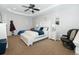 Bright main bedroom featuring a ceiling fan, tray ceiling and decorative shelving at 16301 Hudson Rd, Hudson, CO 80642