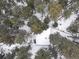 Picturesque aerial landscape view of cabin in a serene, snow-covered setting at 5525 S Twin Spruce Dr, Evergreen, CO 80439